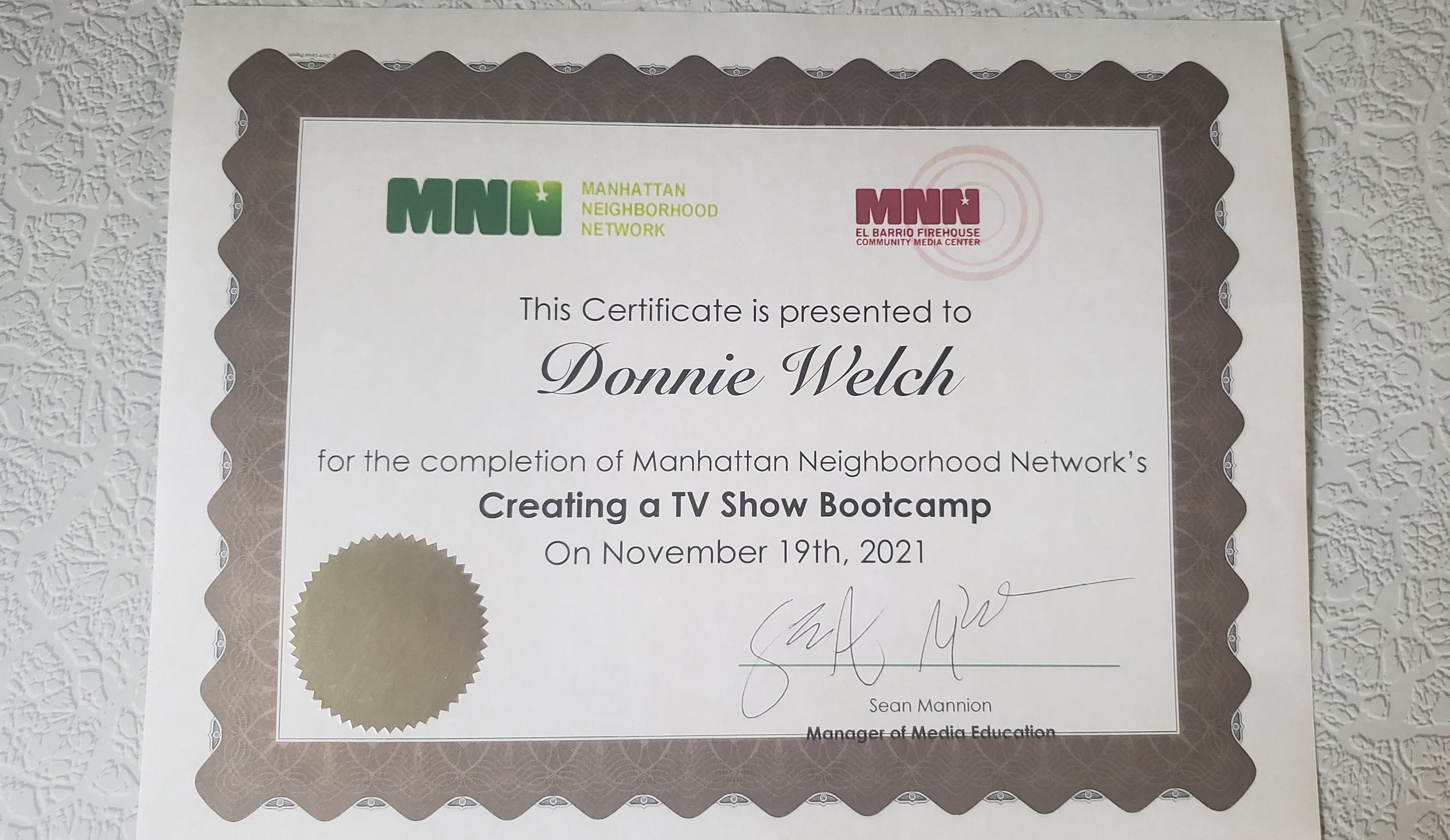 An ornate paper certificate from the Manhattan Neighborhood Network