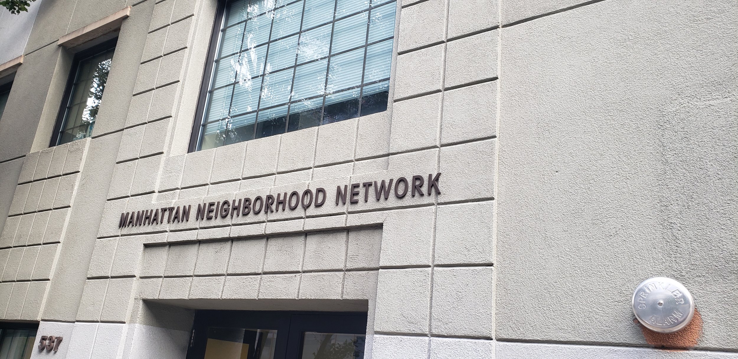 Gray brick entrance to the Manhattan Neighborhood Network.
