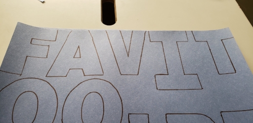 Sharpie outlines of letters on blue construction paper. The letters come to the edges of the paper.