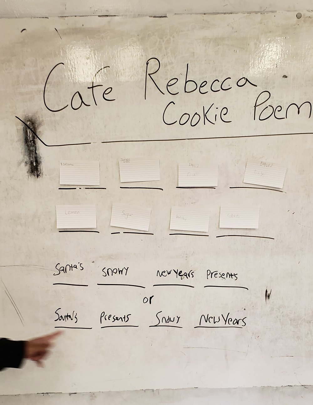 School white board set up with sixteen blank, black lines in a four by four grid. On these blank lines now are notecards with individual words and some hand written words