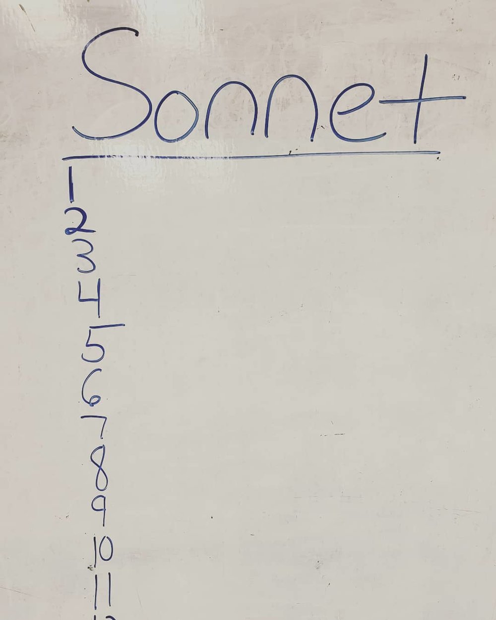 on a white dry erase school board the word Sonnet is written at the top with a vertical stack of numbers 1-14 underneath it. All the writing is in blue.